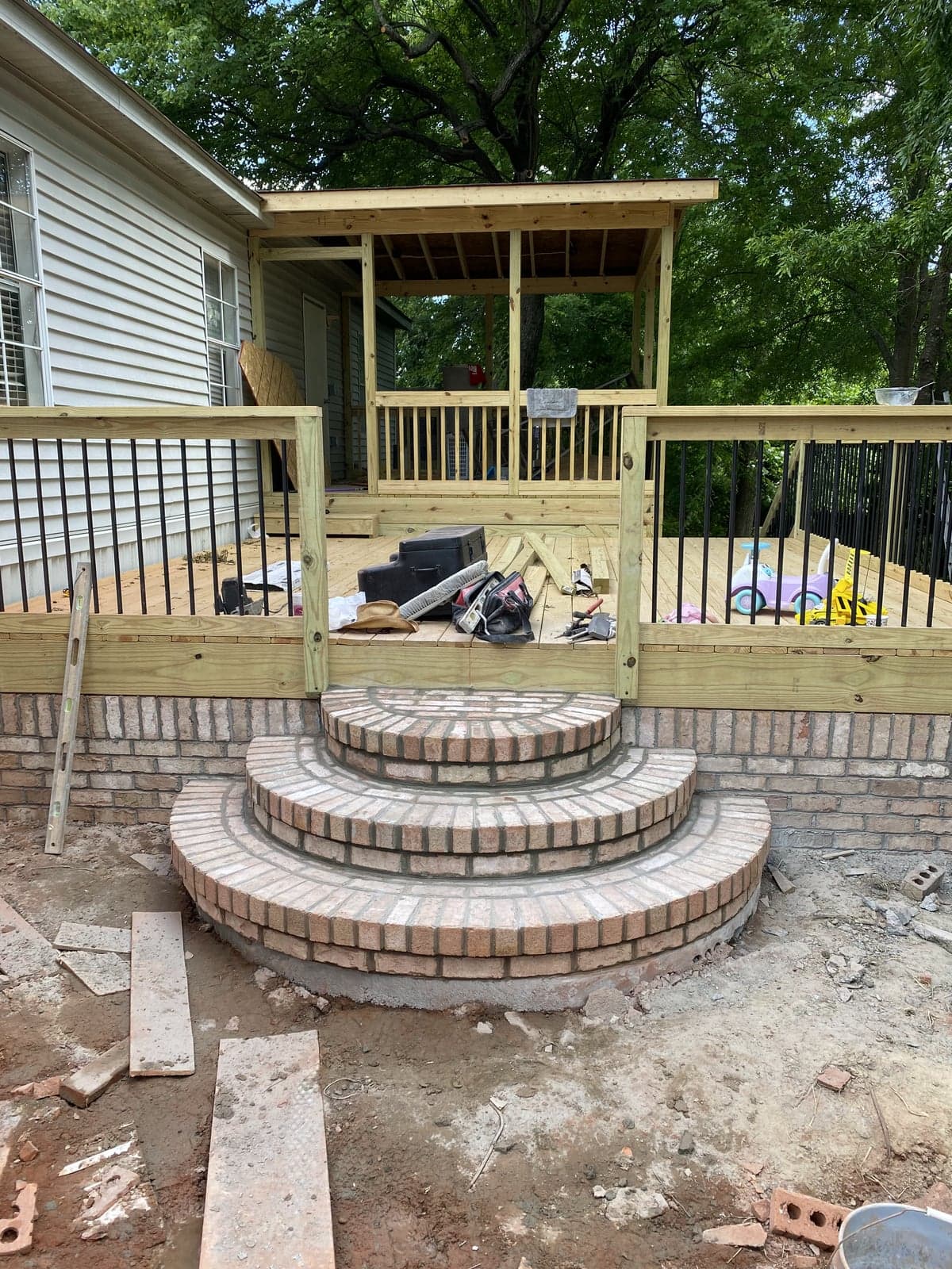 Curved brick steps leading up to a wood deck