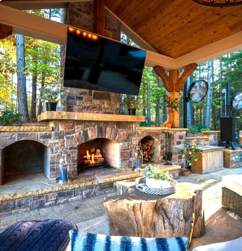Stone outdoor fireplace under a timber pavilion