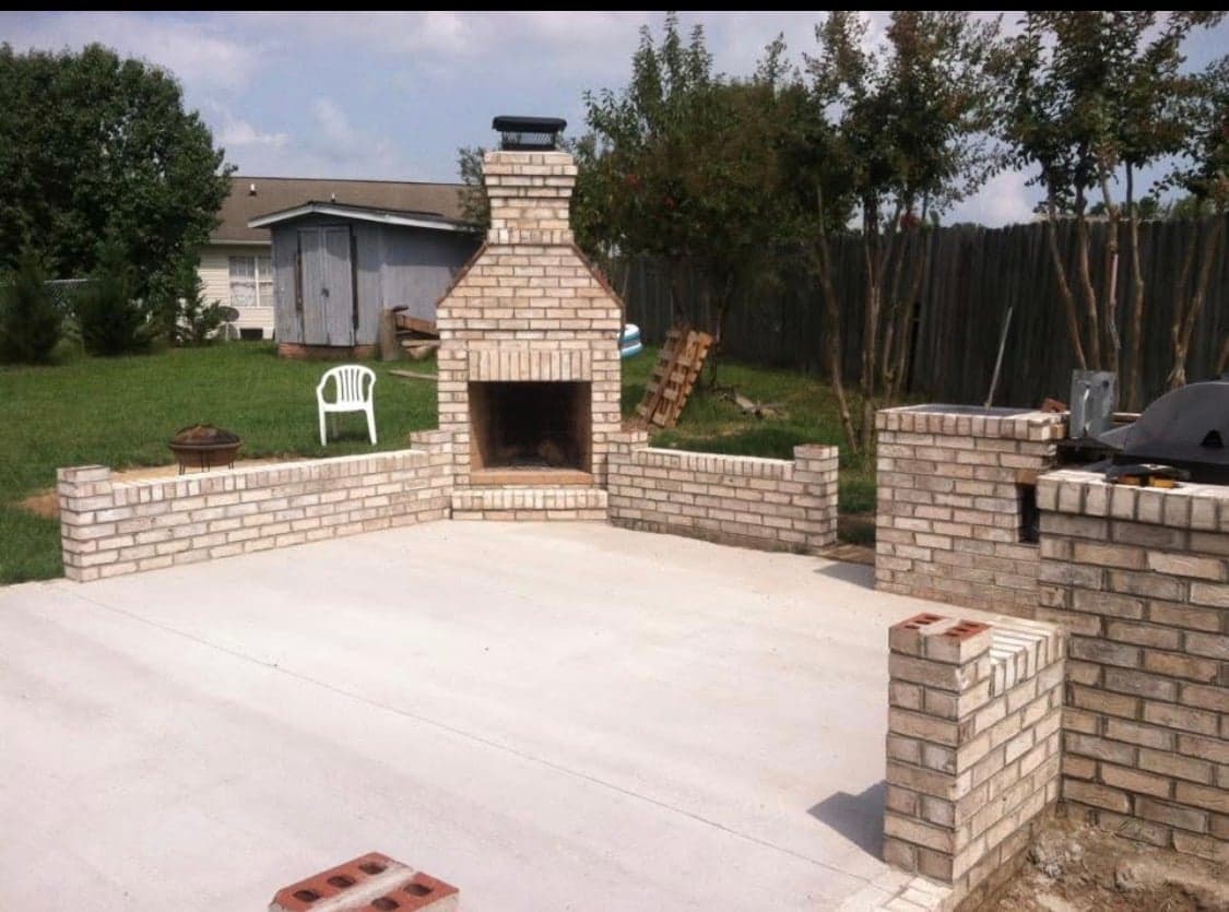 Brick outdoor fireplace with brick patio walls and grill