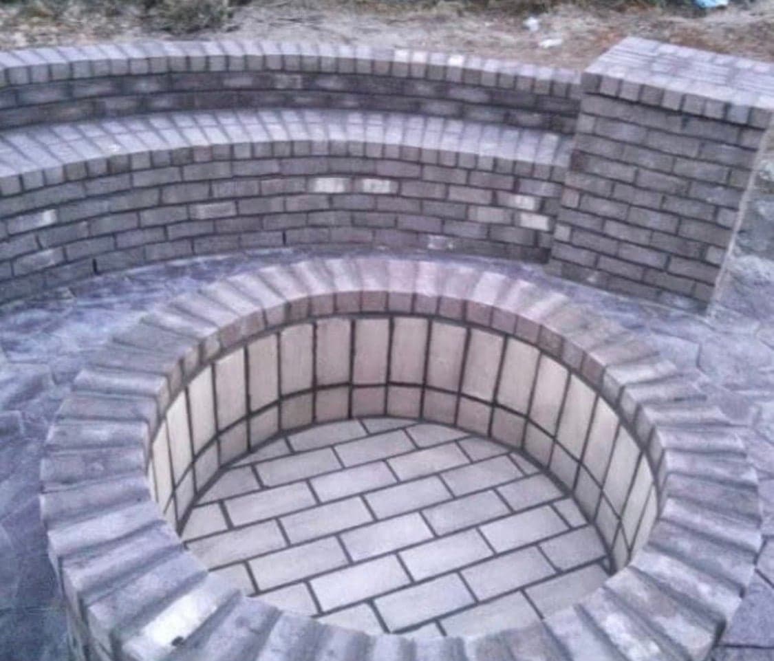 Sunken curved brick fire pit with seating wall