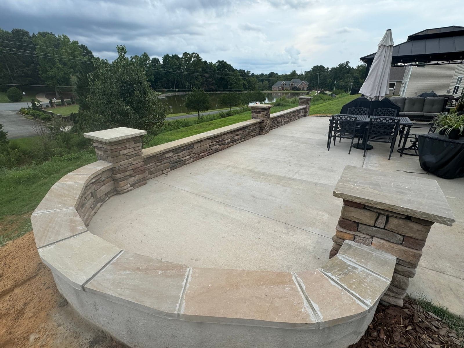 Stone seat wall with curved patio overlooking a lake