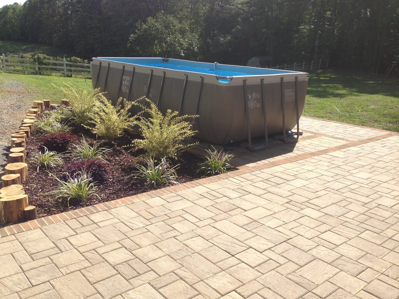 Stamped concrete patio with brick border and pool